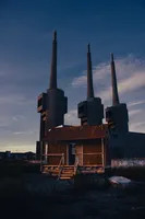 "Un Intruso (uninvited, into chaos)", by Mike Nelson, is a small hut next to the power plant. Built with the remains of the demolished buildings nearby, it seems as if it has always been here, as if it wasn't just an art piece. The visitor is invited to enter and take a look to the chimneys: a megalithic statement of power, not only from the perspective of energy, but also on political, economic, environmental and, above all, human levels; making the observer reflect about their future.