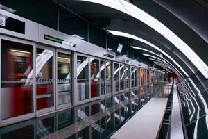 Ciutat de la Justícia metro station, located next to the "City of Justice" (which hosts legal departments) and a shopping mall. This station also has stacked platforms with platform screen doors. The concrete circular structure of the station is exposed, and it has bright curved LED light strips going from top to bottom, like arches. 