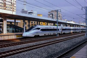 A CRH380D high speed train is stationed at a railway station.