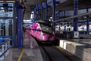 A Renfe class 106 high speed train (Talgo Avril) stationed at the Lleida Pirineus station, between two platforms. It has a purple livery with the Avlo logo. People are deboarding the train.